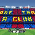 Football fans holding scarves inside a packed stadium