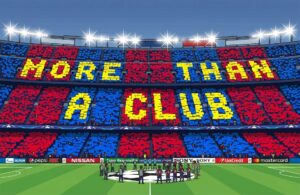 Football fans holding scarves inside a packed stadium